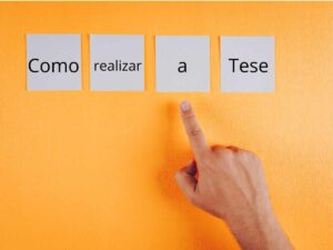 Mão apontando para palavras em post-its que formam a frase "Como realizar a Tese" em fundo laranja.