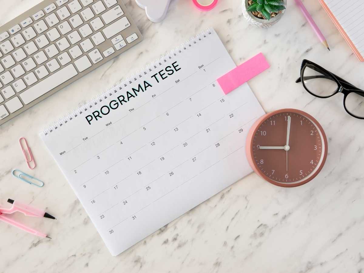 Mesa de trabalho com calendário de programa de tese, relógio e materiais de escritório simbolizando organização e gestão do tempo.
