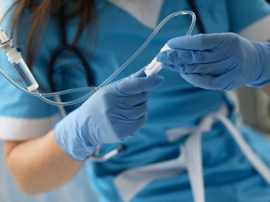 Profissional de saúde preparando equipamento médico com luvas e uniforme, representando a prática e pesquisa em medicina.