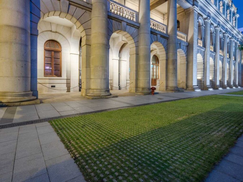 Fachada iluminada de edifício universitário com colunas clássicas, representando a Universidade de Lisboa.