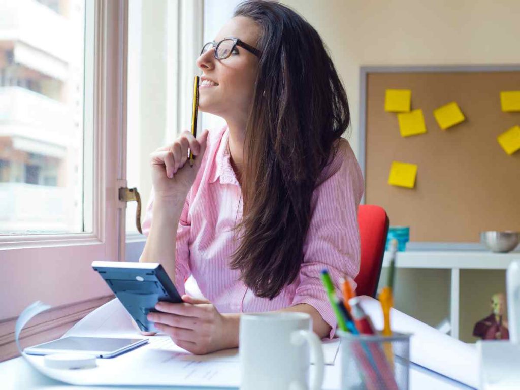 Imagem de mulher estudando com anotações e laptop, representando a preparação para fazer o TFC