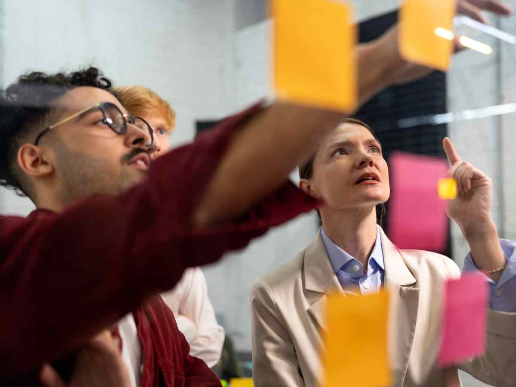 Imagem de grupo de pessoas discutindo e trabalhando juntas, representando a preparação para a exposição do TFC