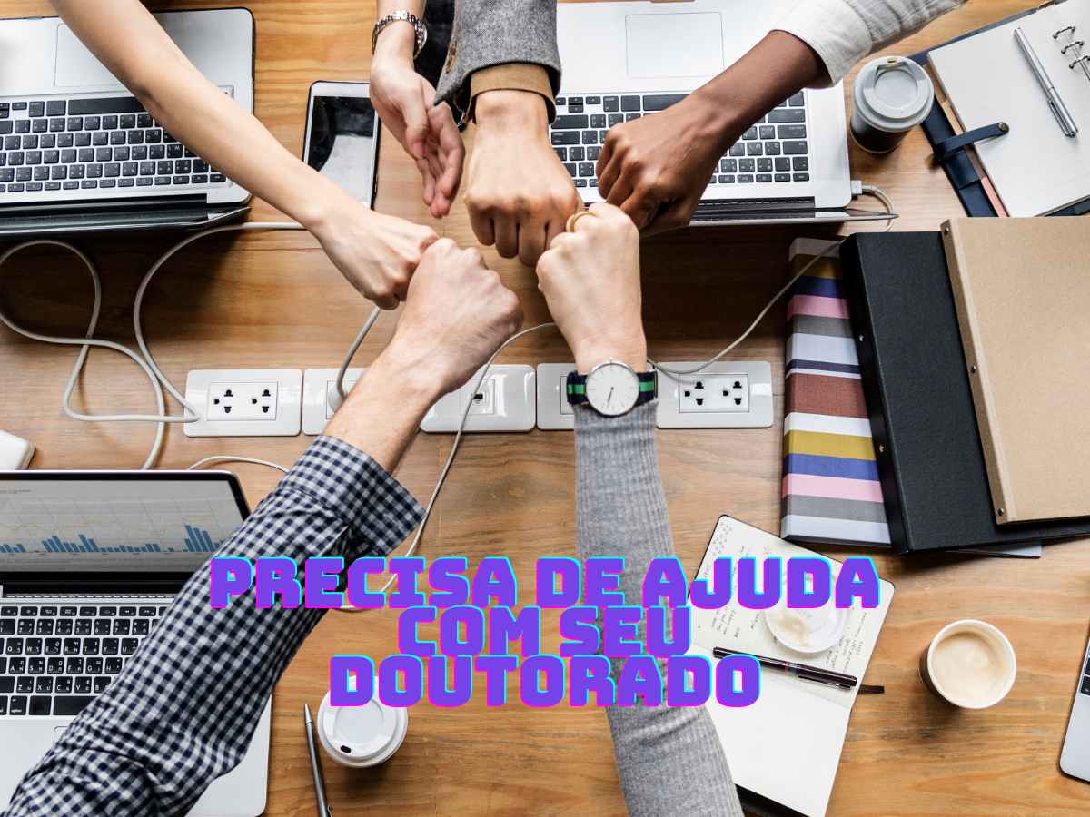 Mãos se unindo em apoio mútuo sobre uma mesa com laptops e documentos