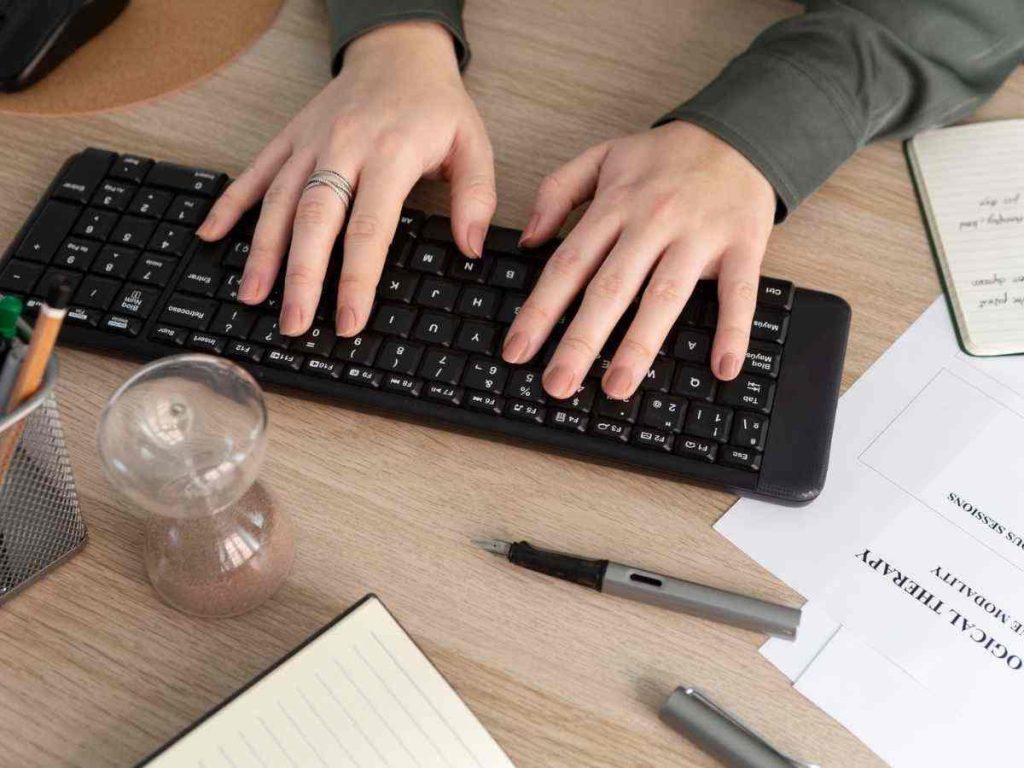 Imagem de mãos digitando no teclado, simbolizando a verificação de plágio em uma tese de doutoramento